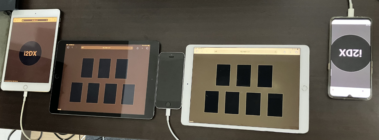 机の上に iPad 2 台、その左右に iPad mini と Android のスマホがある